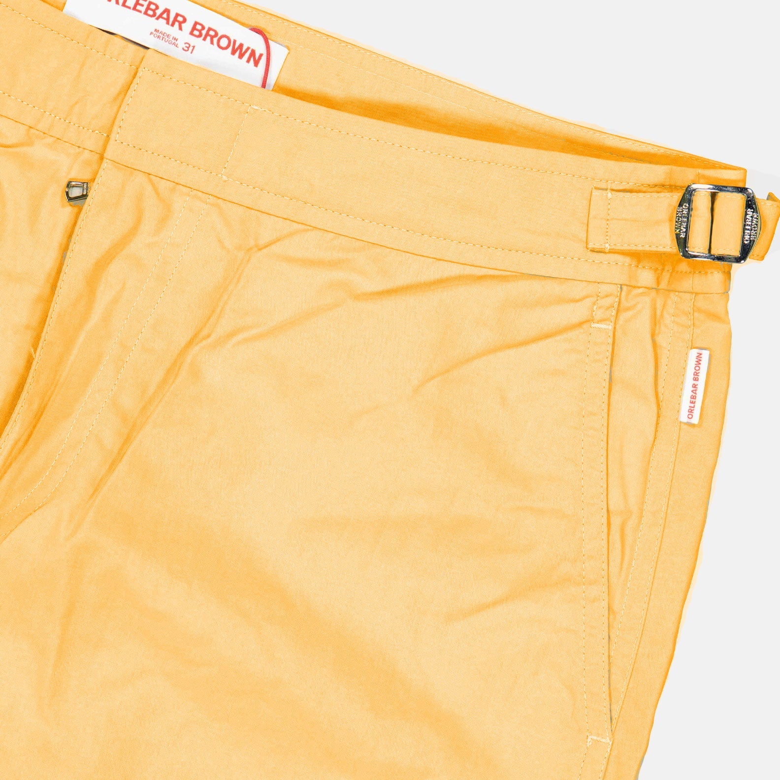 Orlebar Brown swim shorts, luxury swimwear men, orange swim shorts, designer beachwear, high-end men’s fashion