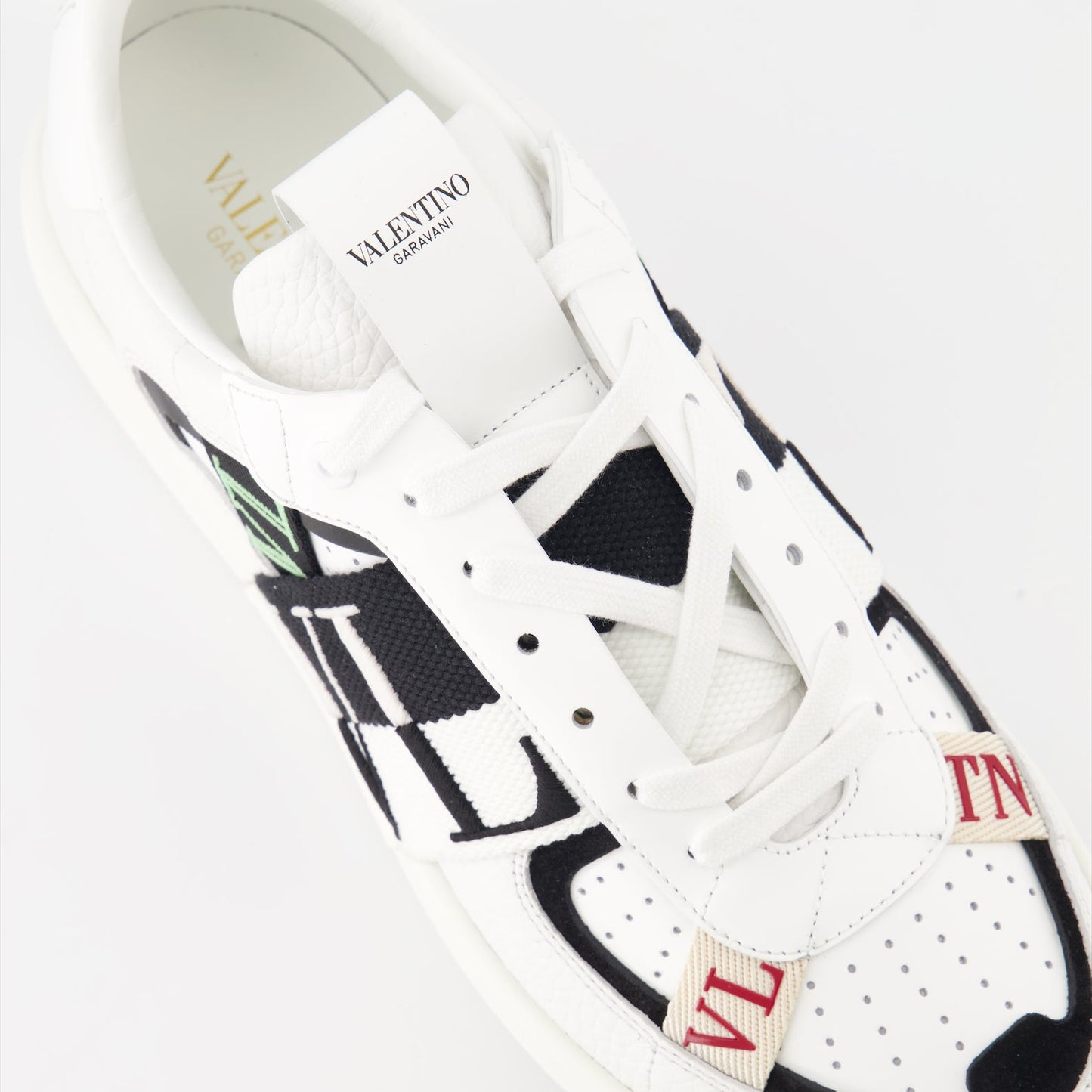 Valentino Garavani sneakers, luxury leather sneakers, white sneakers with black details, designer footwear, high-end fashion sneakers