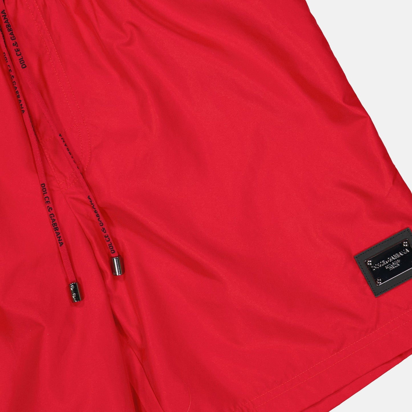 red swim shorts, luxury swimwear, Dolce & Gabbana, logo plaque swim shorts, designer swimwear