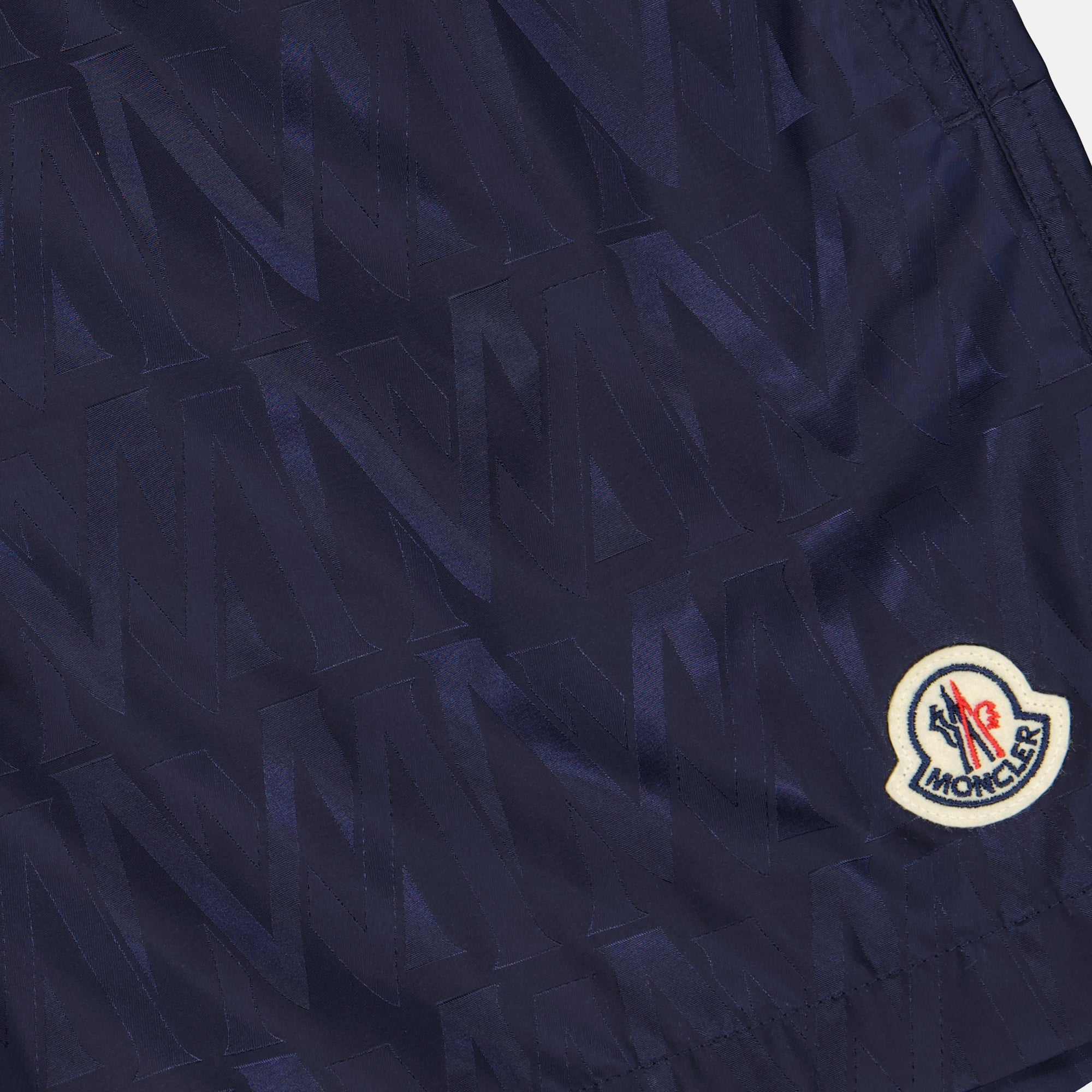 Monogrammed swim shorts, luxury men's swimwear, Moncler swim shorts, designer beachwear, high-end swimwear