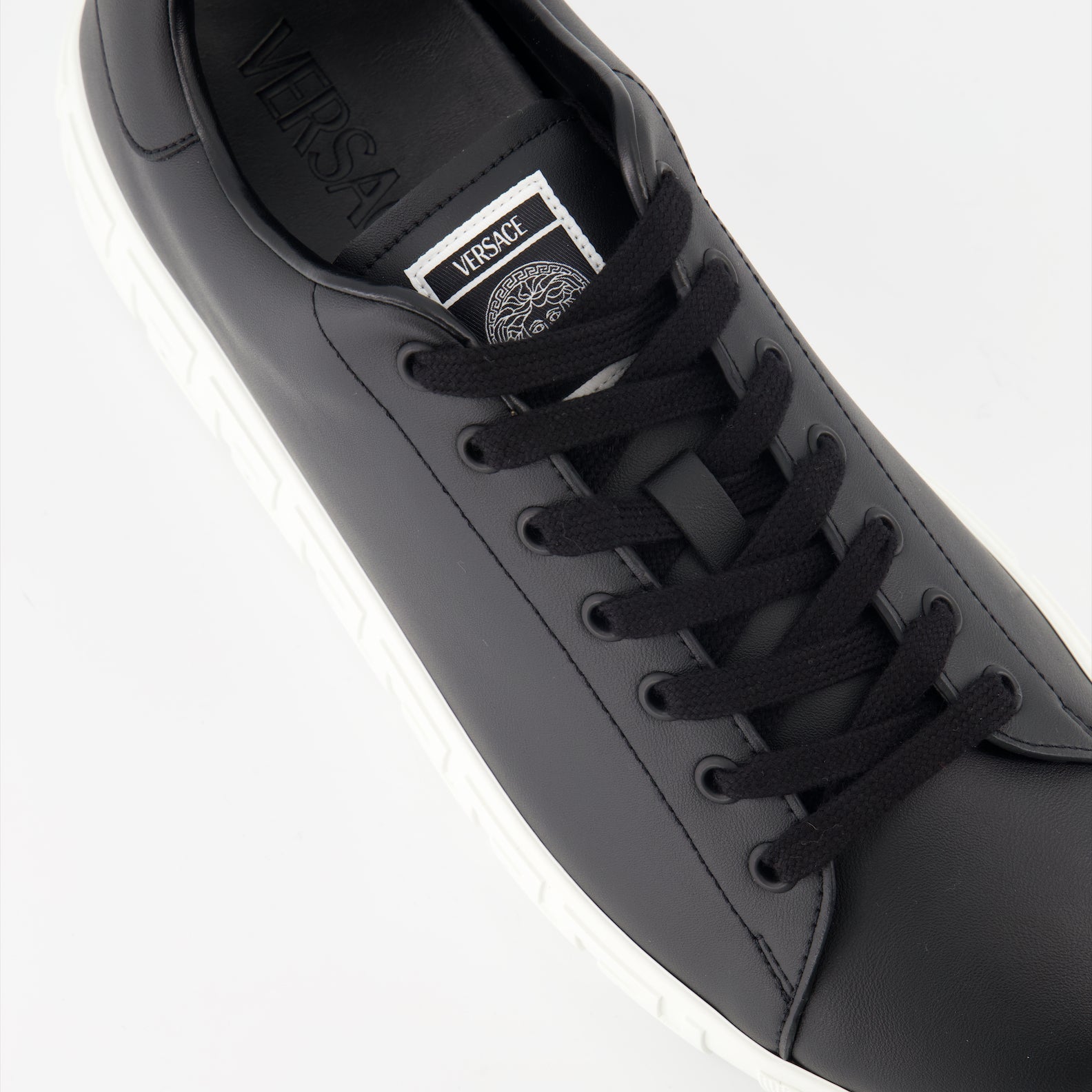 Versace sneakers, luxury footwear, Greca pattern shoes, black designer sneakers, high-end casual shoes