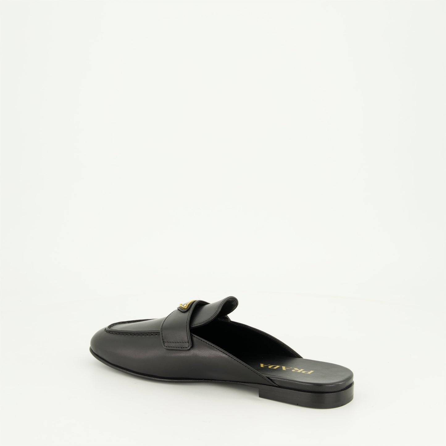 black leather mules, slip-on mules, metal logo mules, amande-shaped toe footwear, monobloc sole shoes