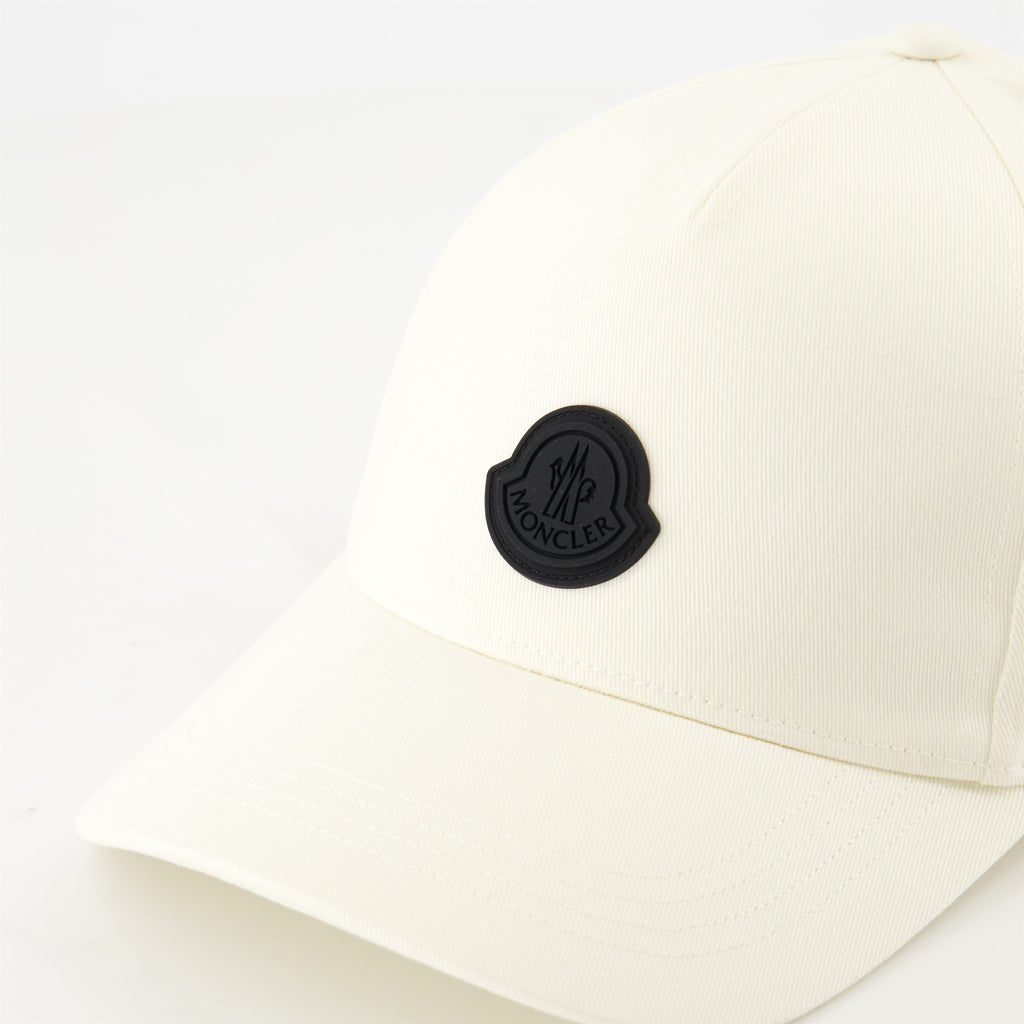 white cap, black logo, adjustable strap, high-quality cotton, contemporary design