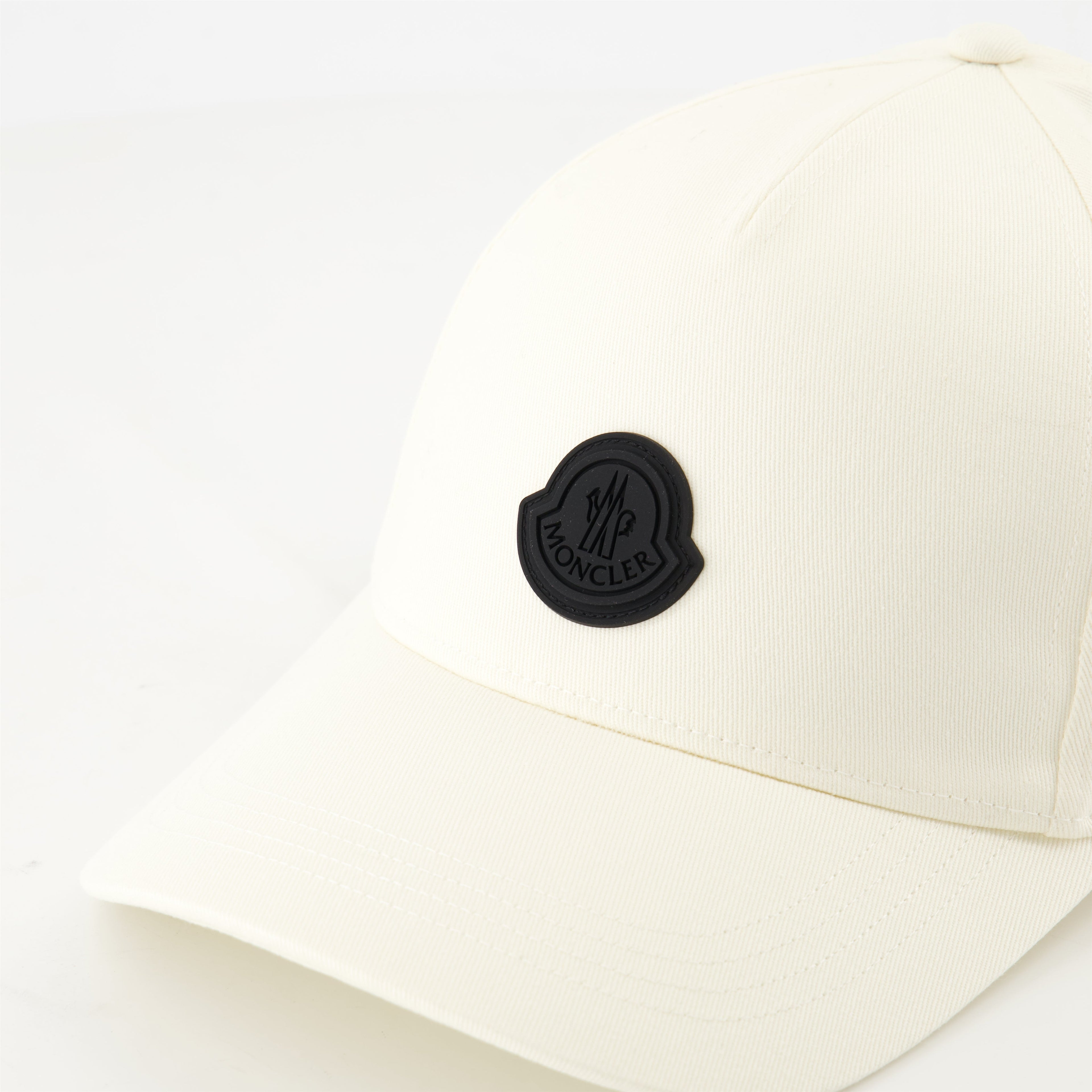 white cap, black logo, adjustable strap, high-quality cotton, contemporary design
