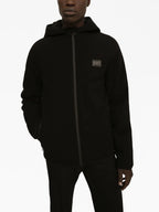 black windbreaker, metal logo plaque, nylon jacket, adjustable hood, zip closure