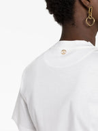 Bild eines weißen Cropped-T-Shirts mit goldenen Details von Rabanne für Damen - Saison Herbst-Winter 2024 - Modellansicht 2