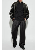 Imagen de polo negro con detalles dorados de Versace para hombres - Temporada primavera-verano 2025 - Vista del modelo 1