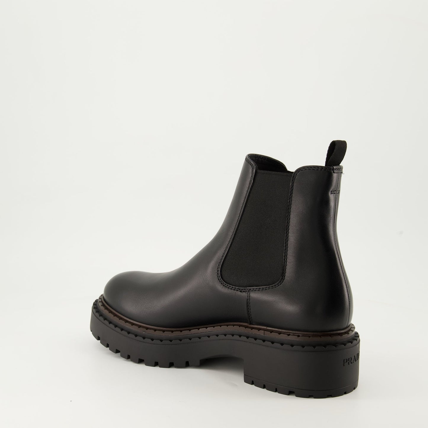 black leather boots, slip-on boots, embossed logo, textured sole, elastic panels