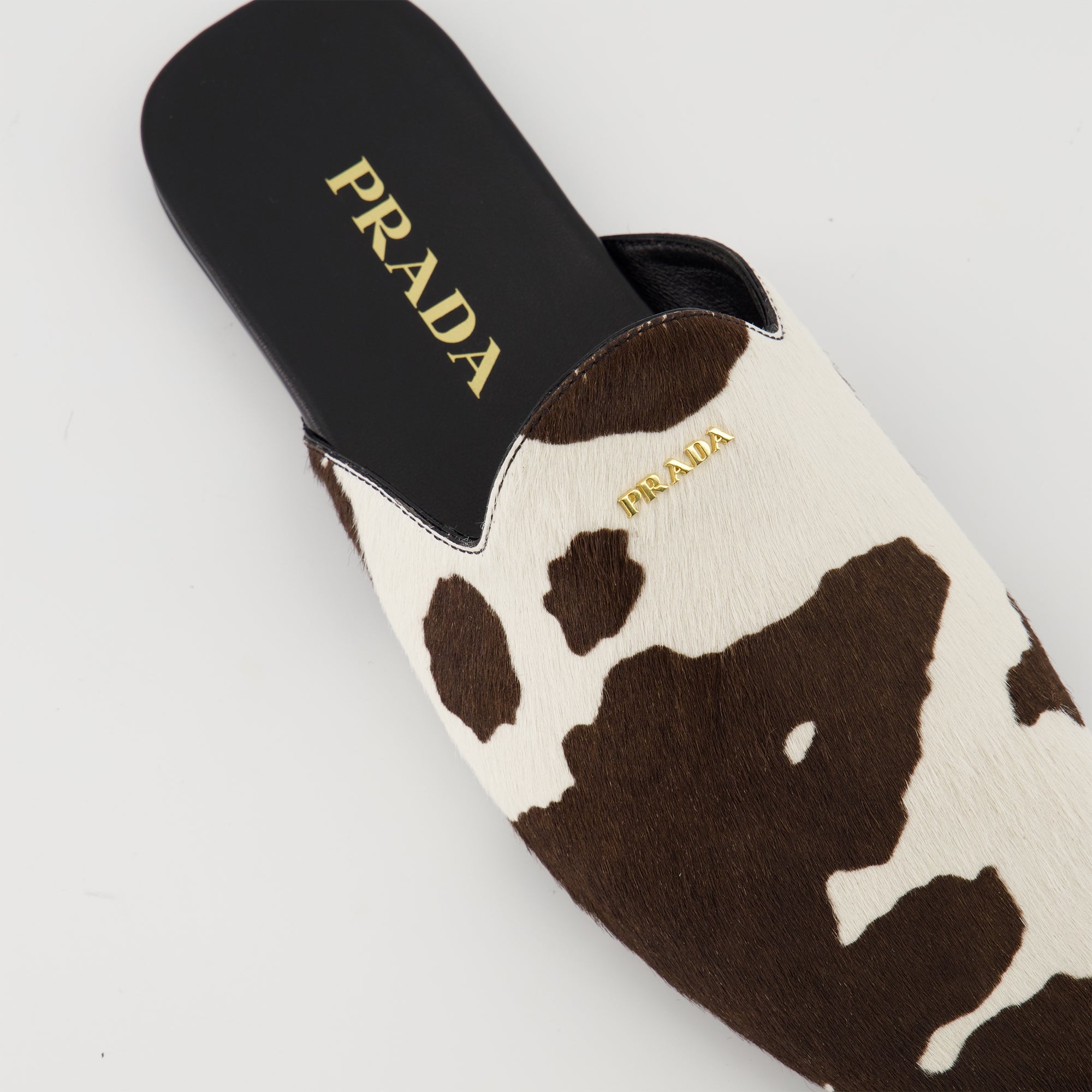 leather mules, Prada shoes, cow printed footwear, Autumn-Winter 2025 collection, metallic logo plaque