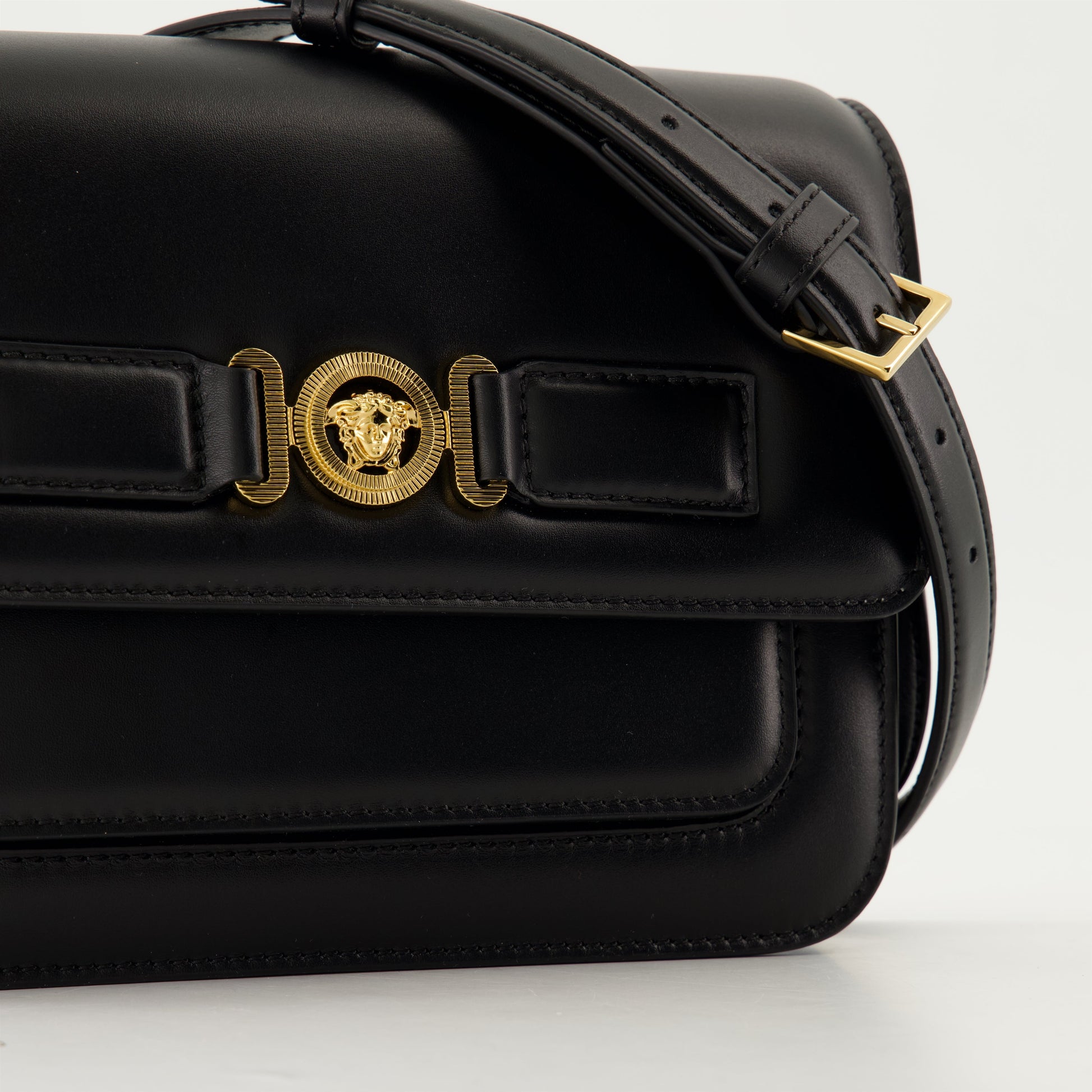 leather satchel, adjustable strap, embossed logo, black bag, Medusa accents