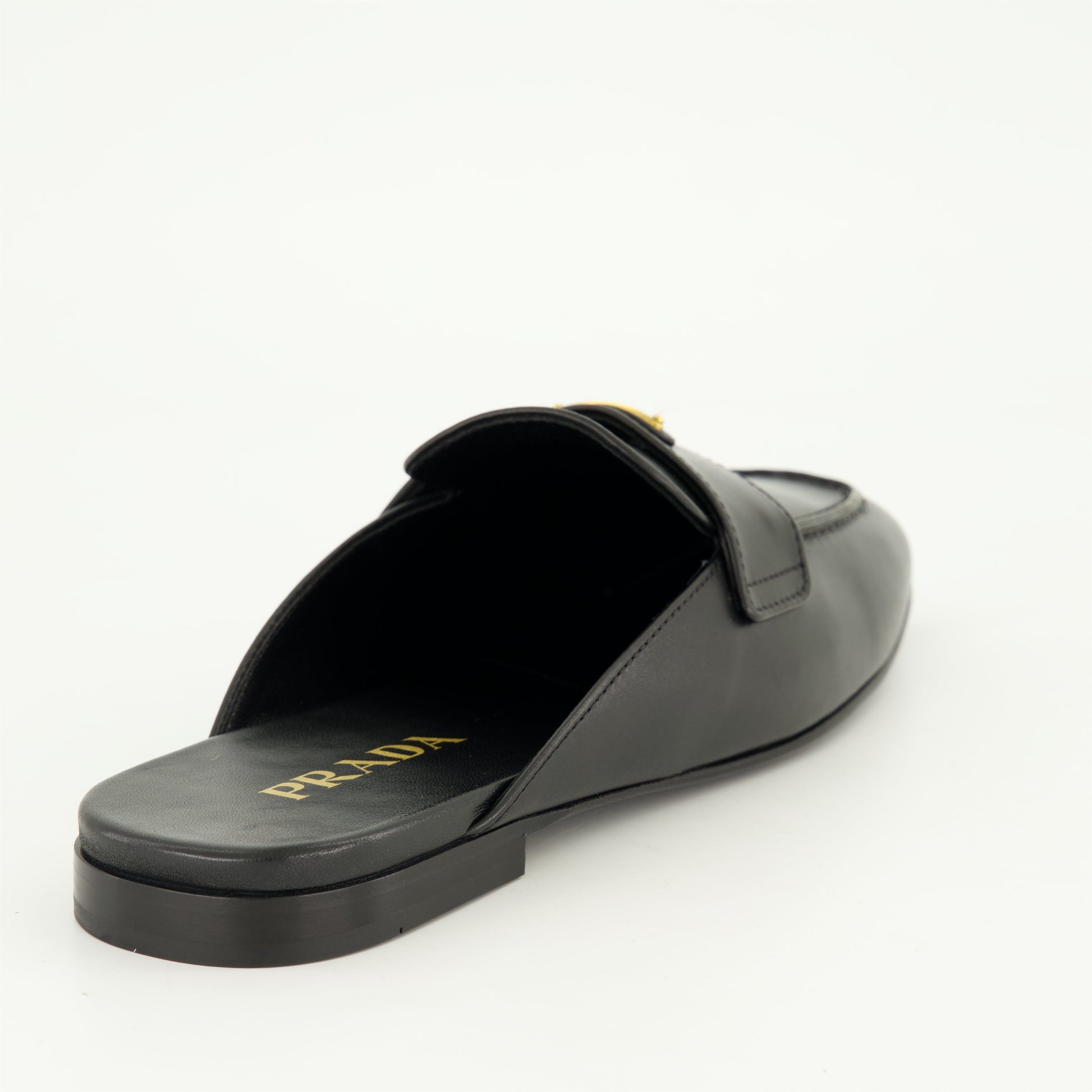 black leather mules, slip-on mules, metal logo mules, amande-shaped toe footwear, monobloc sole shoes