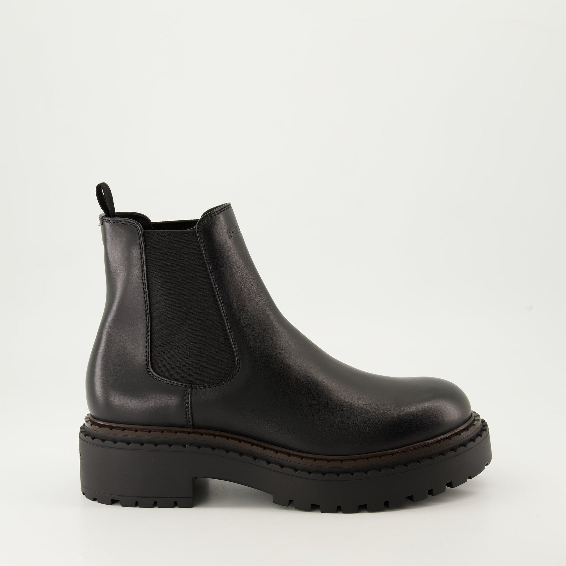 black leather boots, slip-on boots, embossed logo, textured sole, elastic panels