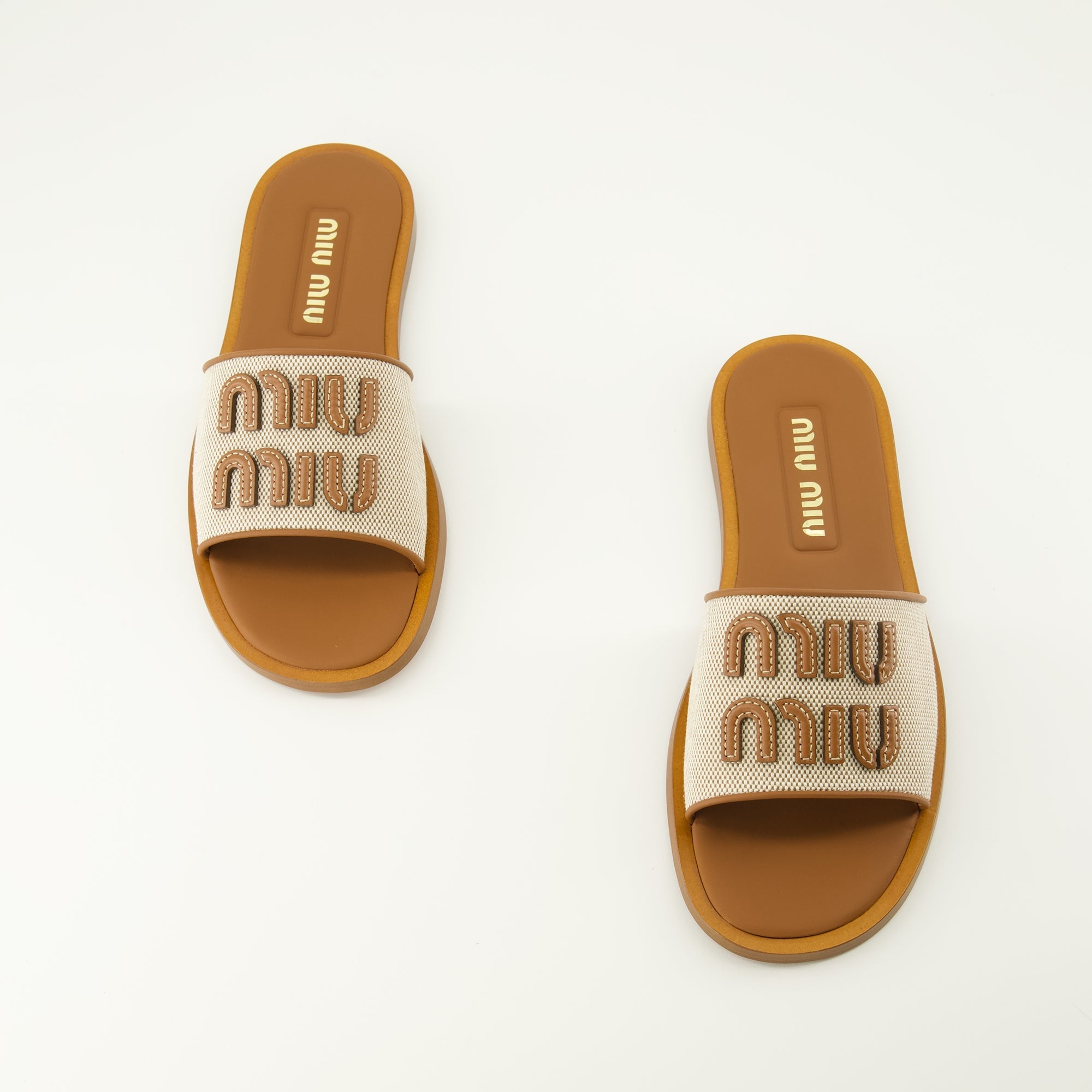 Imagen de mules de lienzo y cuero marrón de Miu Miu para mujeres - Temporada Primavera-Verano 2026 - Vista superior del par