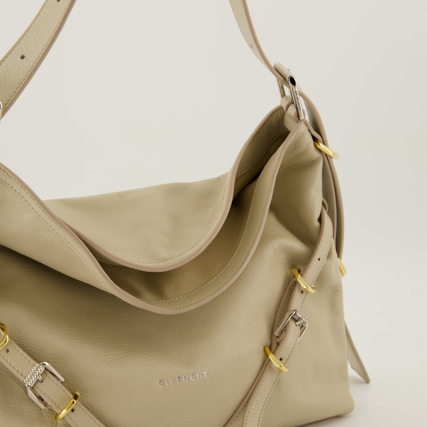 Beige leather bag, adjustable strap bag, designer medium bag, signature metal accents, contemporary fashion bag