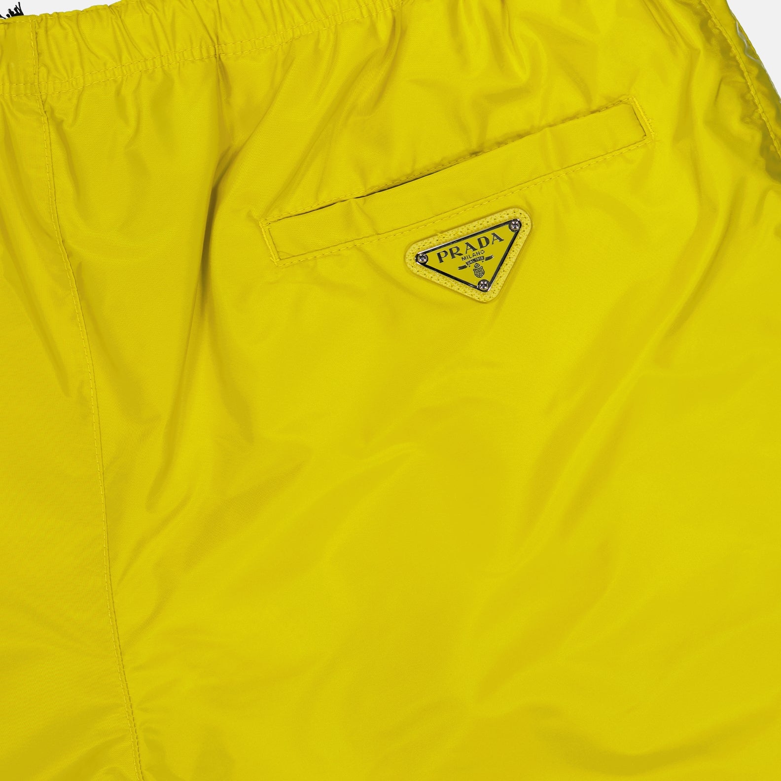 Prada swim shorts, Re-Nylon swimwear, luxury men's swimwear, sustainable beachwear, yellow swim trunks